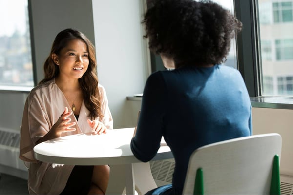 two women sitting on chairs